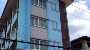A multi-story building with a blue and white facade, large windows, and a central entrance. - TK Residence (Kalasin)