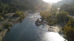Un río serpentea por un valle con colinas al fondo.