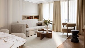Ein modernes Wohnzimmer mit einer Couch, einem Couchtisch, einem Beistelltisch und einem Sessel.