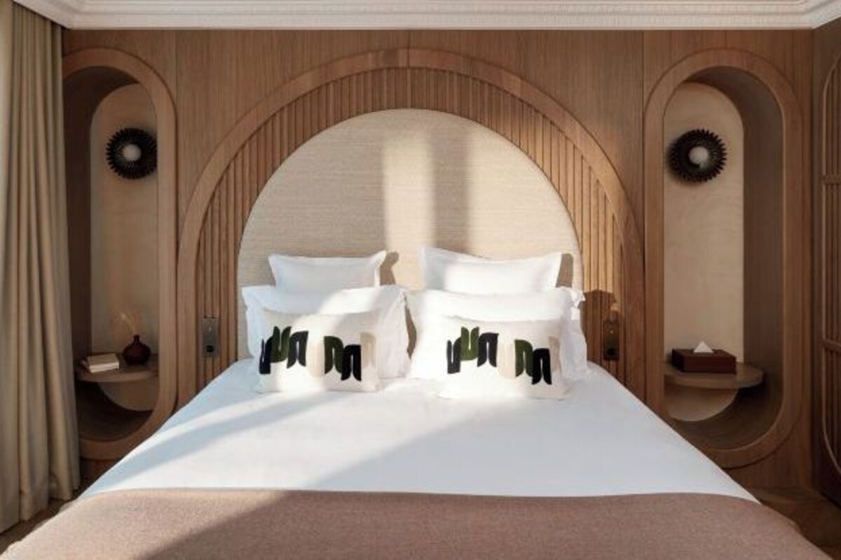 A bedroom with a large bed, two bedside tables, and a wooden headboard.