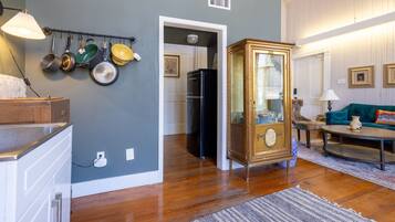 A kitchen with wooden cabinets, a hanging pot rack, and a refrigerator.