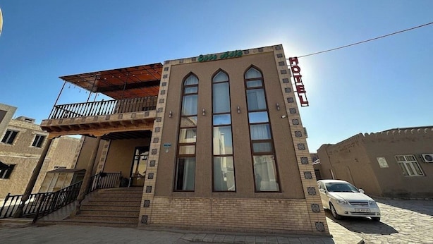 A hotel with a balcony, multiple windows, and a sign indicating it's a hotel. - Euro-asia (Khiva)