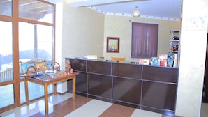 A reception area with a reception desk, a window with a view, a reception sign, and a shelf with books and a globe. - Euro-asia (Khiva)