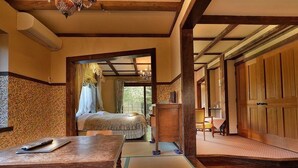 A traditional Japanese room with tatami flooring, a wooden bed, a desk with a remote control, and a large wooden wardrobe. - Izu Kogen Onsen Bettei Ishinoya (Ito)