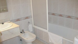 A bathroom with a sink, bidet, toilet, and bathtub. - Hotel Florida (Albacete)