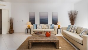 A modern living room with a sofa set, a coffee table, and decorative wall art. - Prainha Family Holidays (Portimão)