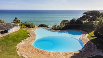 Una piscina al aire libre de temporada, sillones reclinables de piscina