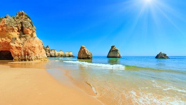 A beach with clear blue water, sandy shore, and rocky formations. - Prainha Family Holidays (Portimão)