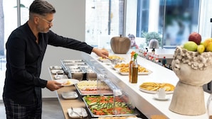 A buffet setup with various food items and condiments. - Epavli City Hostel (Chania)