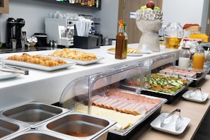 A buffet with various food items, including pastries, salads, and meats. - Epavli City Hostel (Chania)