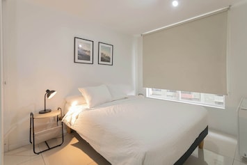 Relax in this cozy bedroom with a comfortable queen-sized bed and soothing decor, perfect for a restful night's sleep.