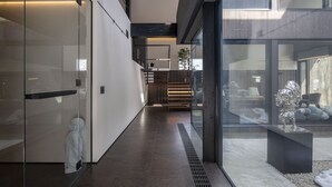A modern interior with a glass door, a staircase, and a view of the outside. - Meikeikyo Hanazono (Kutchan)