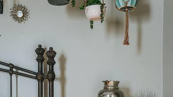 A bedroom with a bed, a nightstand, a lamp, and decorative items.