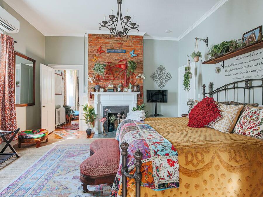 A room with a fireplace, a bed, a sofa, and a brick wall.