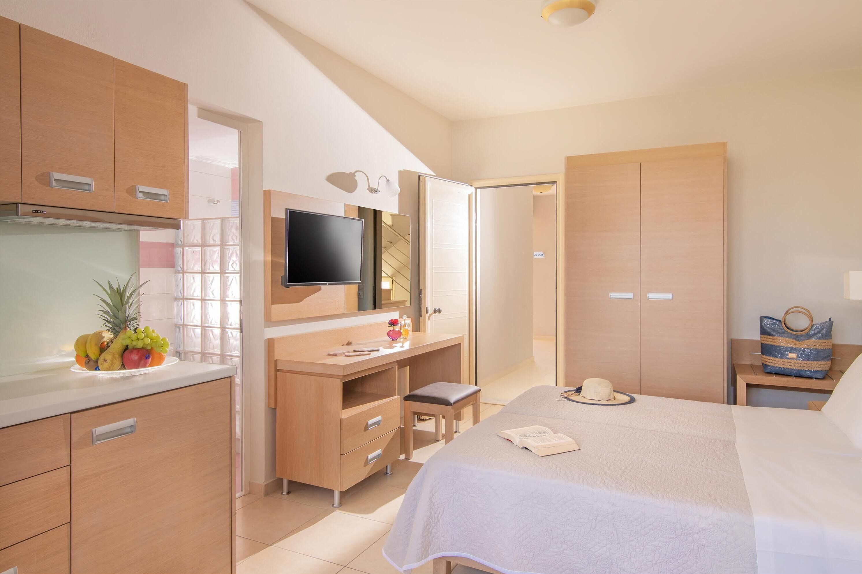 Une chambre d’hôtel équipée d’un lit, d’un bureau, d’une télévision et d’une armoire.