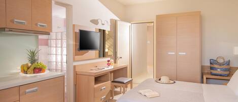 A hotel room with a bed, a desk, a TV, and a wardrobe.