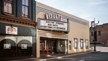 A vintage theater with a marquee advertising 'VISULITE' and 'DOCTOR STRANGE BAD GUYS EVERYTHING EVERYWHERE'.