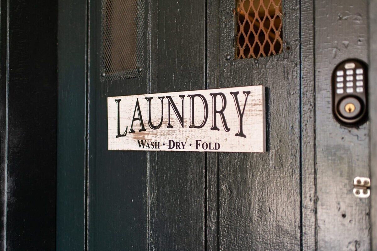 A sign on a door that reads "LAUNDRY Wash, Dry, Fold."