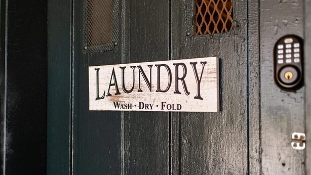 A sign on a door that reads "LAUNDRY Wash, Dry, Fold."