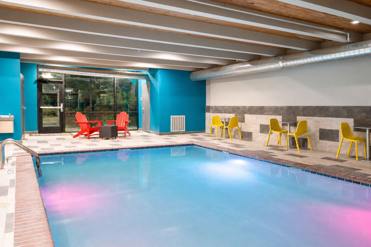 Dive into a calm indoor pool with cozy seating.