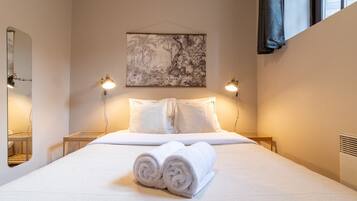 1 habitación, escritorio y tabla de planchar con plancha