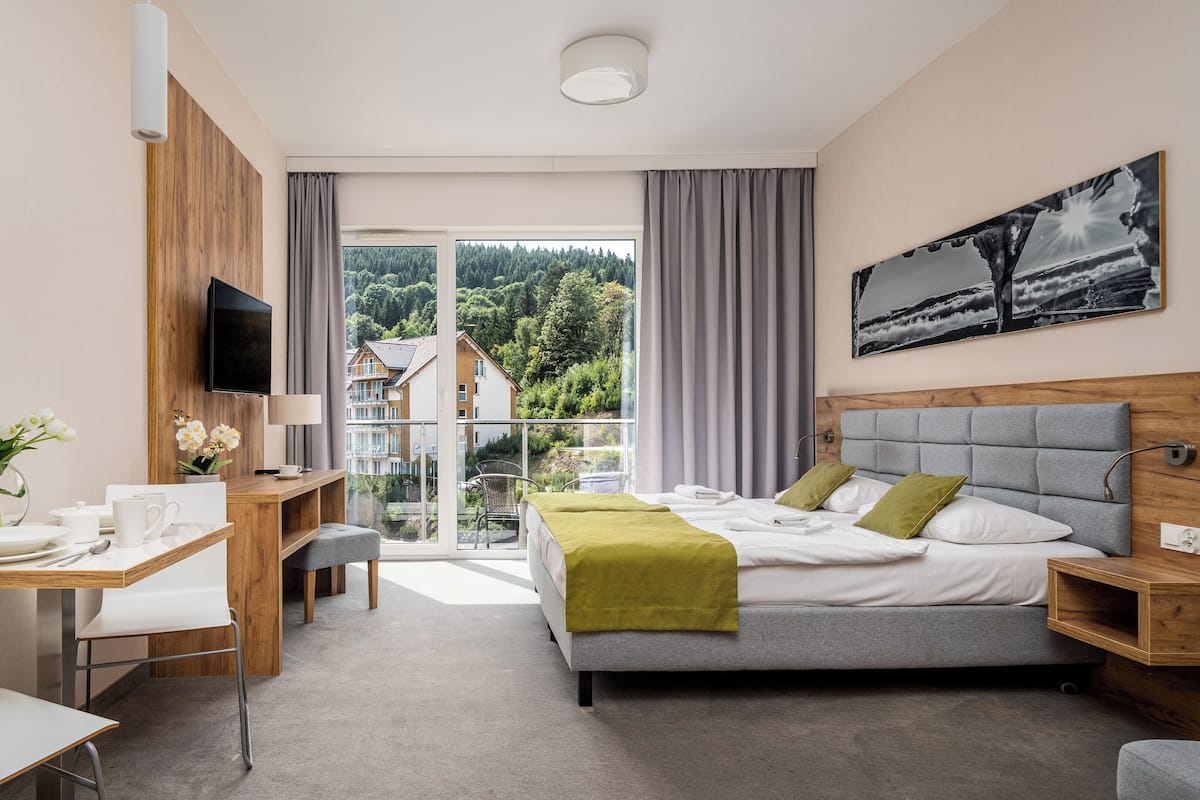 Una habitación de hotel moderna con una cama, un escritorio y una televisión.