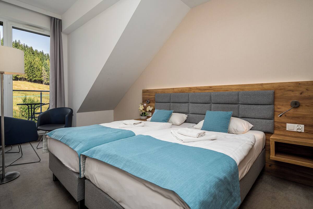 Una habitación de hotel moderna con una cama grande, un escritorio y una silla.