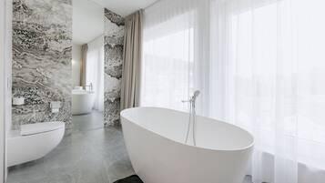 A modern bathroom with a freestanding bathtub, a toilet, and a sink.