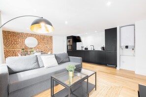 Relax in this stylish living space with a comfortable sofa, coffee table, and modern kitchen.