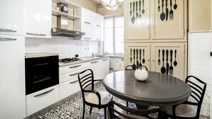 A modern kitchen with white cabinets, a gas stove, a built-in oven, and a dining table with chairs. - Amazing apartment in Loano with WiFi (Loano)