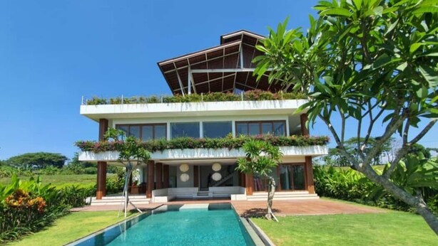 Una casa moderna de dos pisos con piscina delantera.