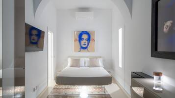Ein modernes Hotelzimmer mit einem großen Bett, einem Fernseher und einem Schreibtisch.