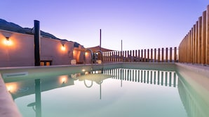 A serene pool area with a clear reflection, surrounded by a wooden fence and a mountain backdrop. - La Mirage Villa (Kournas)