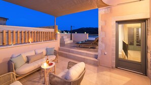 A terrace with a sofa, chairs, and a table with candles. - La Mirage Villa (Kournas)