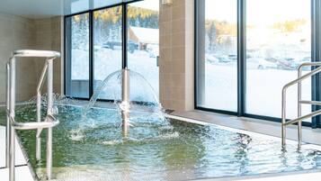Swimmers can enjoy the pool's water jets and scenic views through large windows.