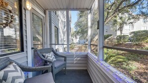 A covered porch with wicker furniture and a view of the neighborhood. - Arcadian Dunes 1st-floor Gem: Pool & Beach Access! (Myrtle Beach)