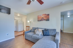 Relax in this stylish living room with a comfortable sofa, flat-screen TV, and a beautiful painting above.