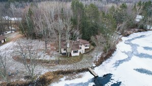 A house surrounded by trees and a frozen lake. - Mason Cabin w/ Private Dock on Marengo Lake! (Mason)