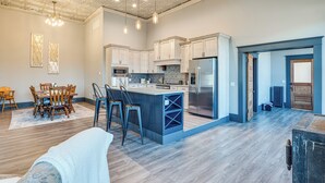 A spacious kitchen with a central island, wooden dining table, and chairs. - Florence Vacation Rental w/ Rooftop Deck! (Florence)