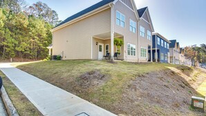 A two-story house with a front porch, a small garden, and a paved driveway. - Atlanta Home w/ Patio, 8 Mi to Downtown + Aquarium (Atlanta)
