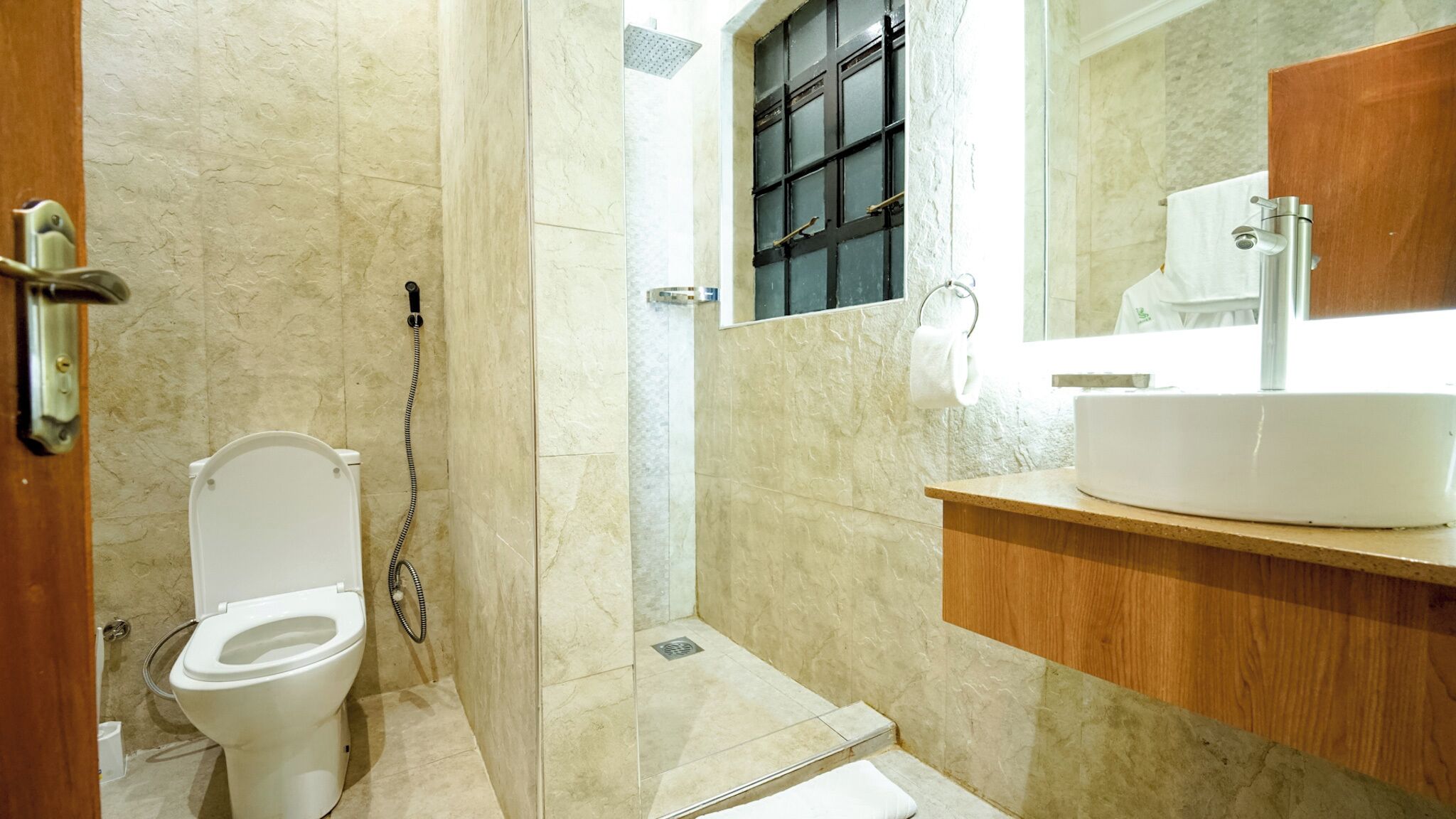 A bathroom with a toilet, shower, and sink.