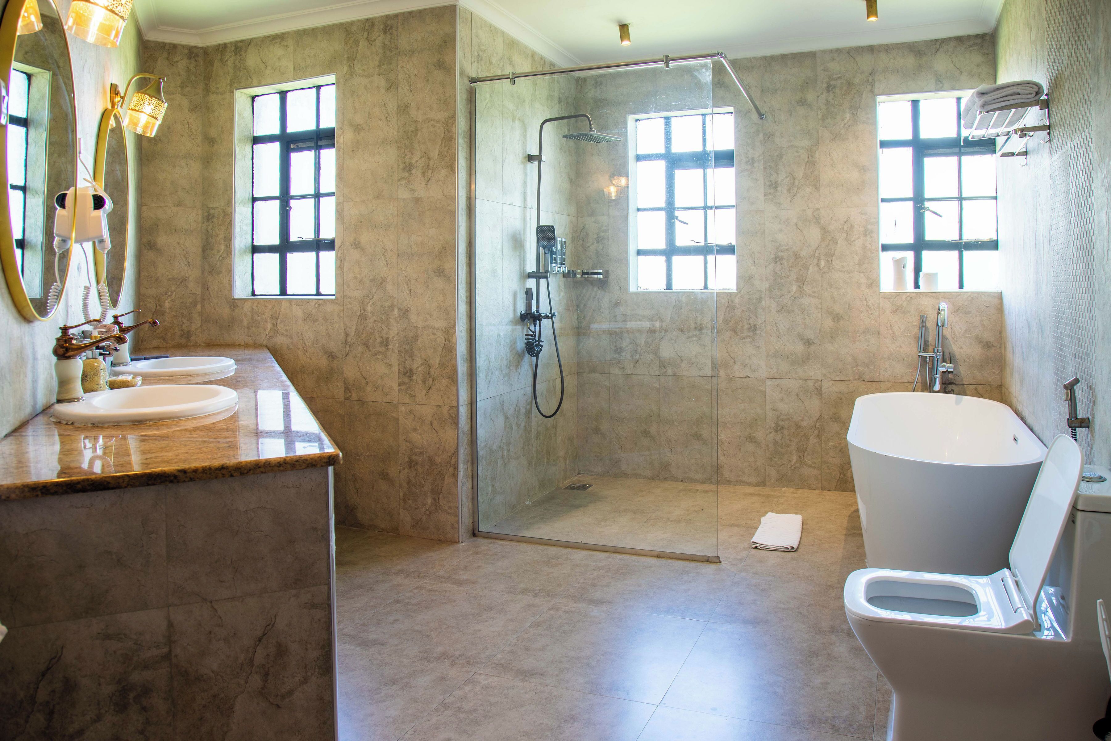 Ein Badezimmer mit einer Duschkabine, einer großzügigen Badewanne und zwei Waschbecken.