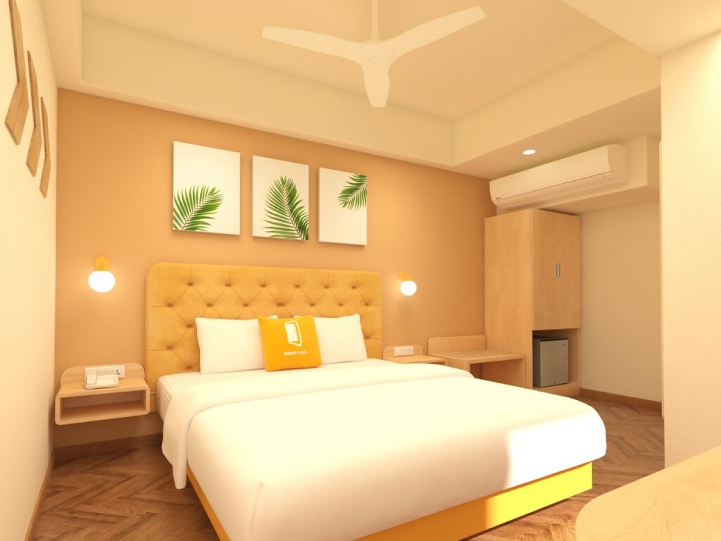 Une chambre d’hôtel avec un grand lit, un ventilateur de plafond et des œuvres d’art accrochées au mur.