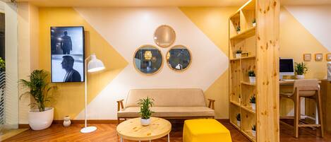 Un intérieur moderne avec un canapé, une table ronde et une étagère en bois.