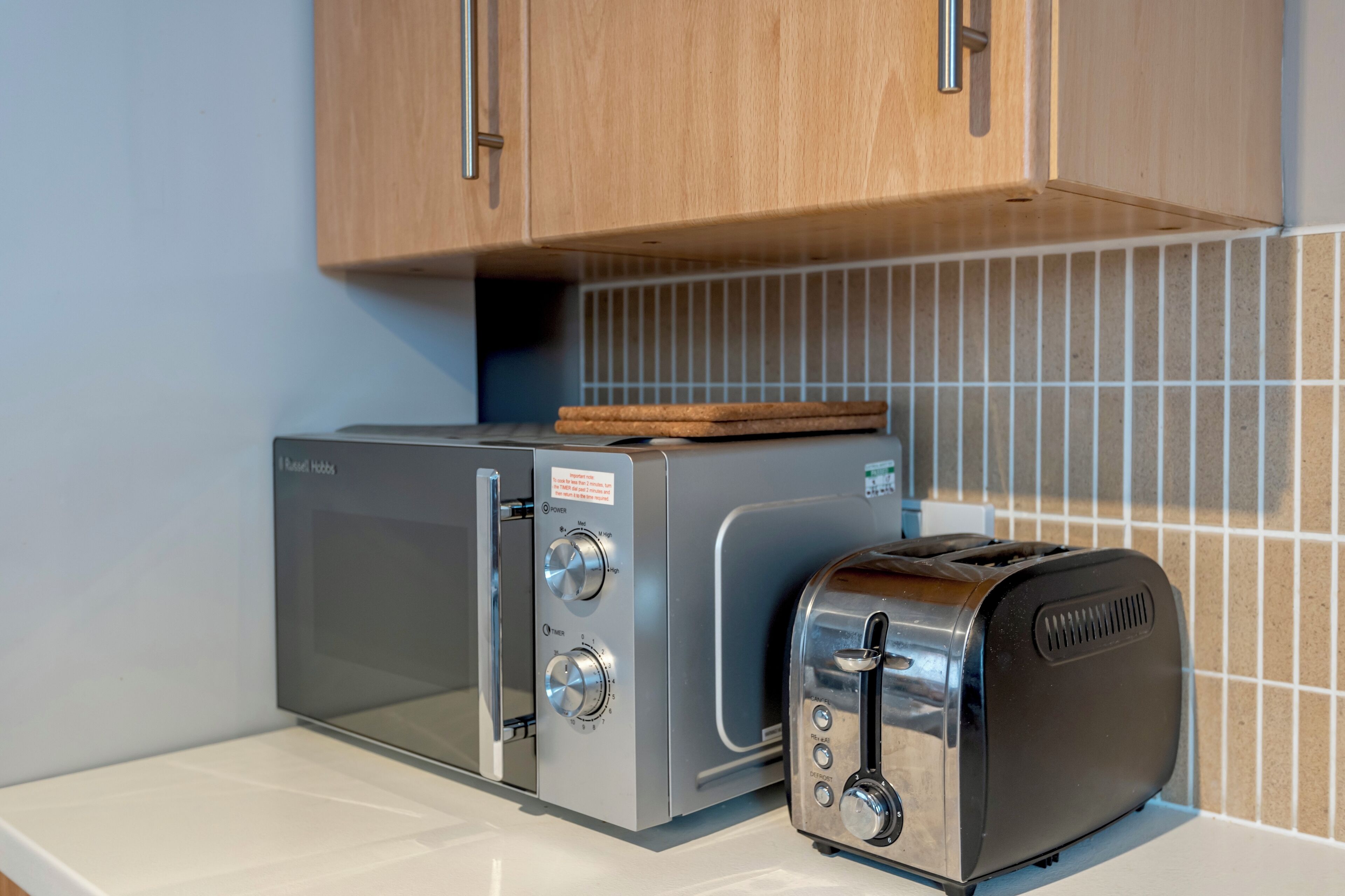A kitchen with a toaster and a microwave.