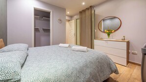 A bedroom with a bed, a dresser, a mirror, and a closet. - Levante Home in the Centre of Bari (Bari)