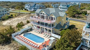 A multi-story hotel with a pool, balconies, and a view of the beach. - A Raye Of Sunshine: Ocean Views, Saltwater Pool (Corolla)