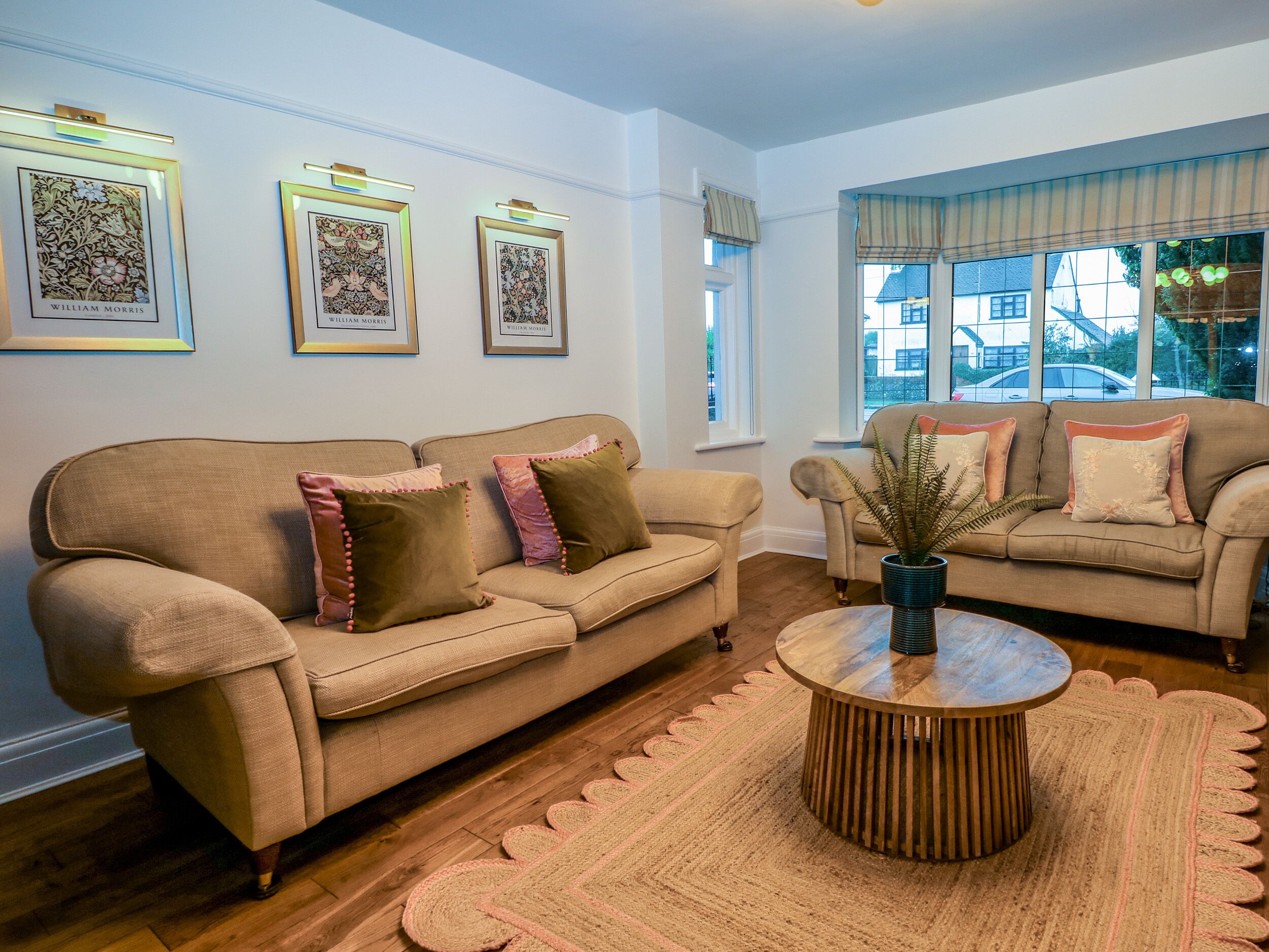 A living room with two sofas, a coffee table, and framed artwork on the wall.