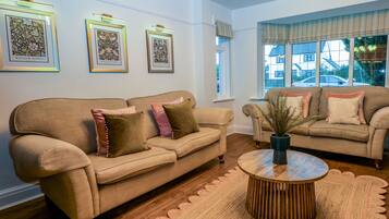 A living room with two sofas, a coffee table, and framed artwork on the wall.