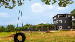 Un bâtiment moderne à deux étages, doté d’un toit plat et de grandes fenêtres.